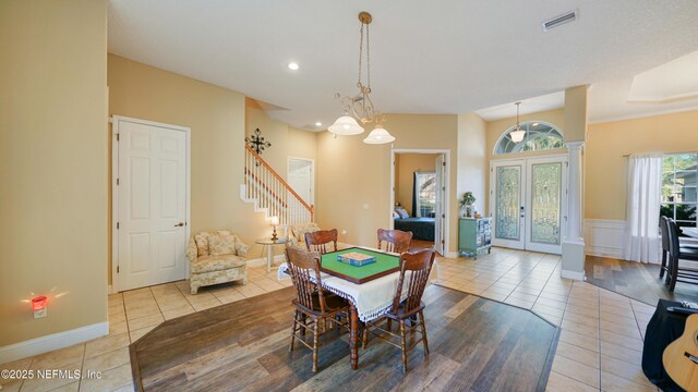 dining room with an inviting chandelier, light tile patterned floors, and french doors