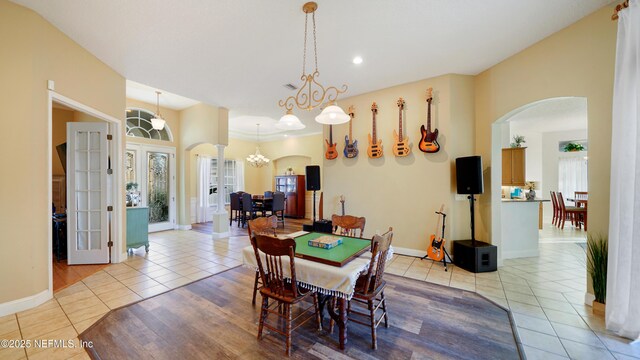 tiled dining area featuring french doors and a notable chandelier