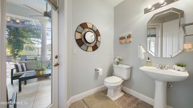 bathroom featuring toilet, ceiling fan, plenty of natural light, and tile patterned flooring