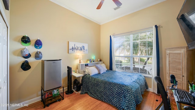 bedroom featuring ceiling fan, a closet, wood-type flooring, and ornamental molding