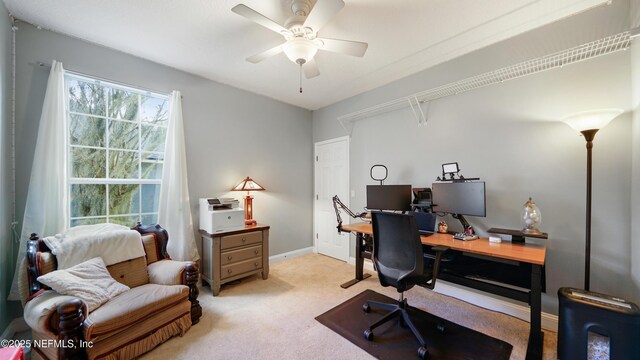 carpeted office space featuring ceiling fan