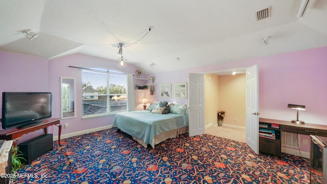 bedroom featuring carpet flooring, a textured ceiling, and vaulted ceiling