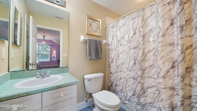 bathroom with vanity, curtained shower, toilet, and a textured ceiling