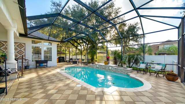 view of swimming pool featuring glass enclosure and a patio area