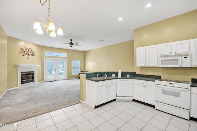 kitchen featuring white cabinetry, sink, white appliances, light carpet, and ceiling fan with notable chandelier