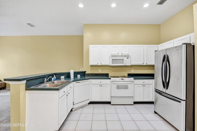 kitchen featuring white appliances, sink, kitchen peninsula, light tile patterned floors, and white cabinetry