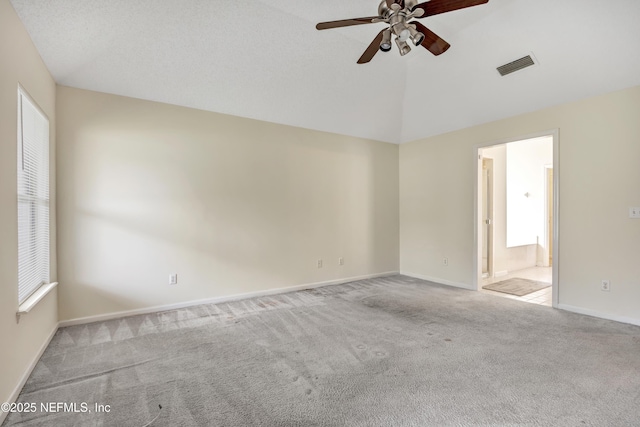 unfurnished room with light carpet, vaulted ceiling, and ceiling fan