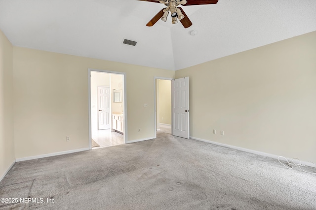 spare room featuring ceiling fan, light carpet, and vaulted ceiling