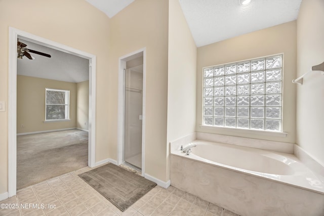 bathroom featuring separate shower and tub, ceiling fan, and a textured ceiling