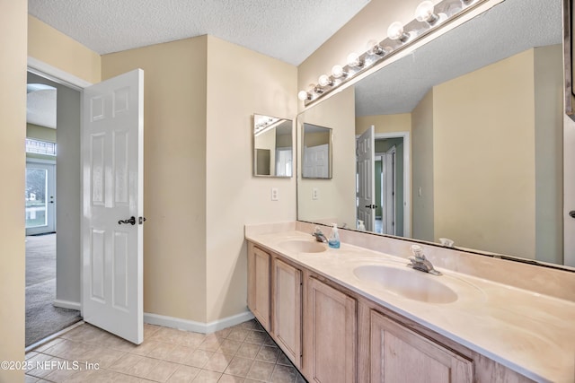 bathroom with vanity, a textured ceiling, and tile patterned flooring