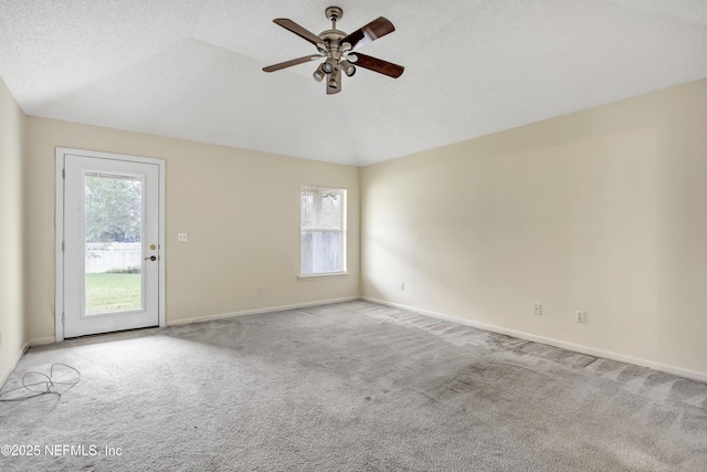 carpeted empty room featuring ceiling fan, a textured ceiling, and vaulted ceiling