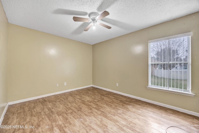 unfurnished room with ceiling fan, a textured ceiling, and light wood-type flooring