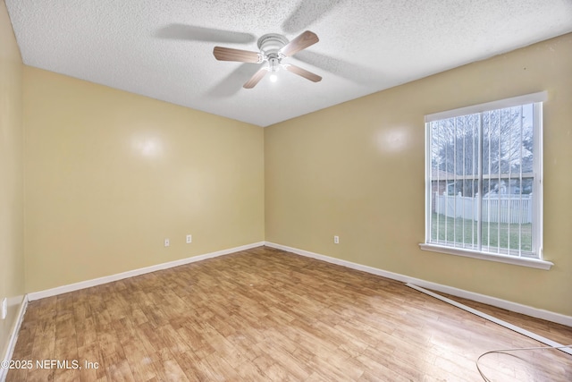 empty room featuring ceiling fan, light hardwood / wood-style flooring, and a textured ceiling