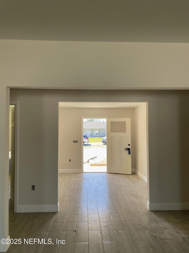 entrance foyer with baseboards and wood finished floors