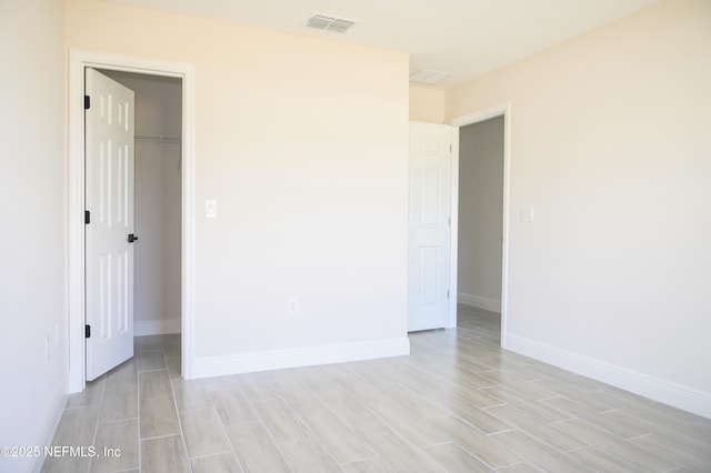 16521 SW 31st Ter, Ocala, FL 34473 - unfurnished bedroom with wood finish floors, baseboards, a spacious closet, and a closet