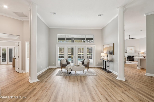 living area with ceiling fan, crown molding, french doors, and decorative columns