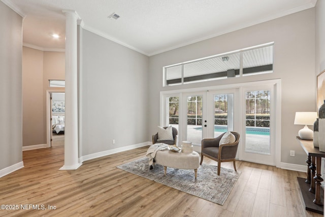 living area featuring crown molding, french doors, and light wood-type flooring