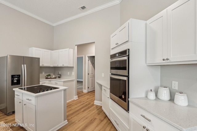 kitchen with light hardwood / wood-style floors, a center island, white cabinetry, and stainless steel appliances