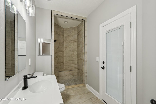 bathroom with toilet, sink, and tiled shower