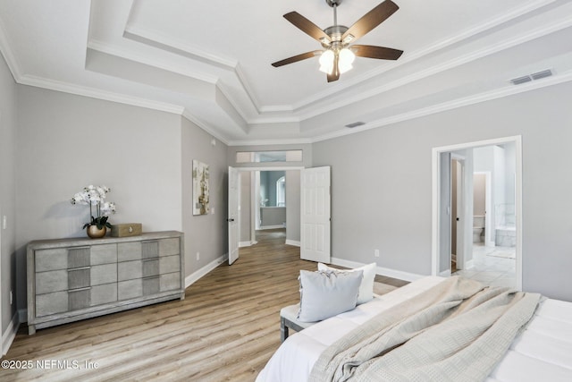 bedroom with ceiling fan, connected bathroom, crown molding, and a raised ceiling