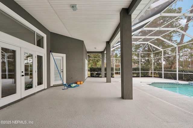 view of pool featuring glass enclosure, a patio area, and french doors