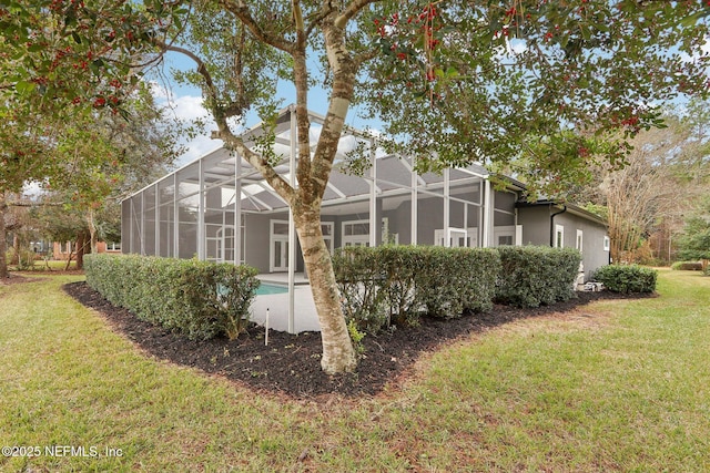 view of property exterior with glass enclosure and a yard