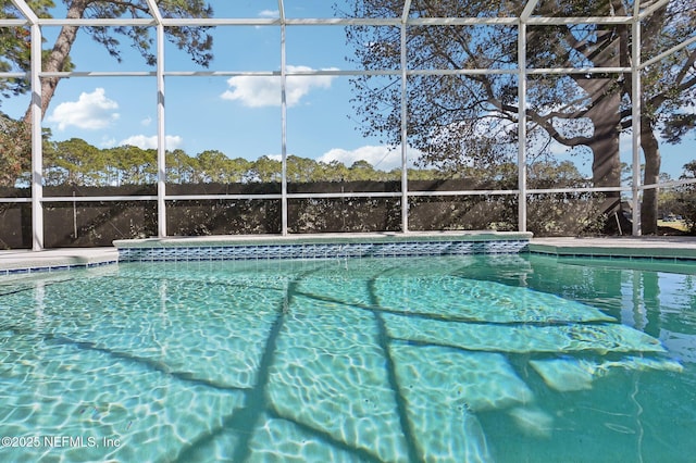 view of pool featuring glass enclosure