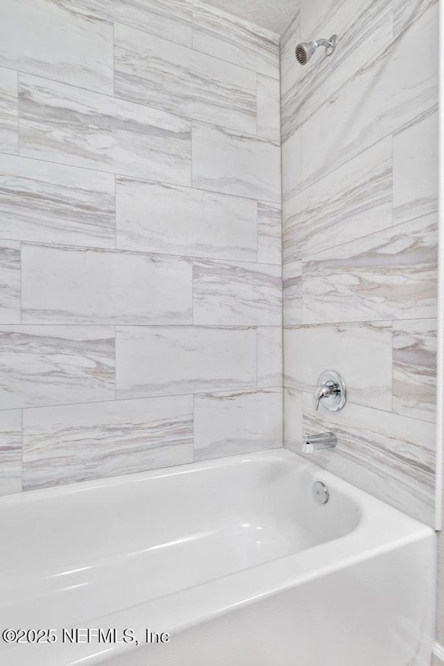 bathroom with tiled shower / bath combo