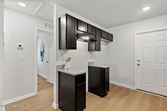 kitchen featuring light stone countertops and light hardwood / wood-style flooring