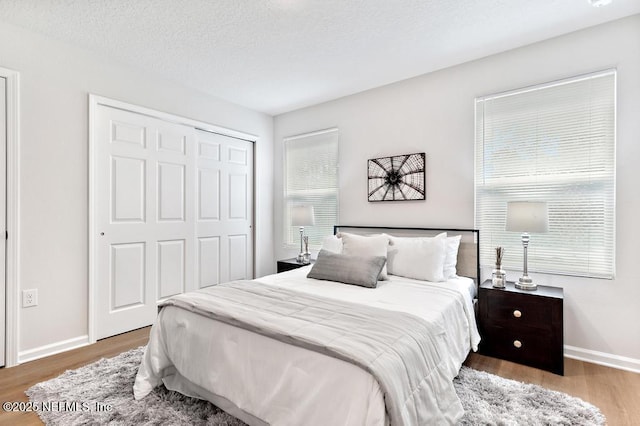 bedroom featuring dark hardwood / wood-style flooring, a closet, and a textured ceiling