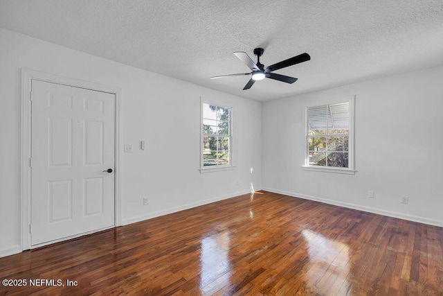 unfurnished room featuring a wealth of natural light, dark hardwood / wood-style floors, and ceiling fan