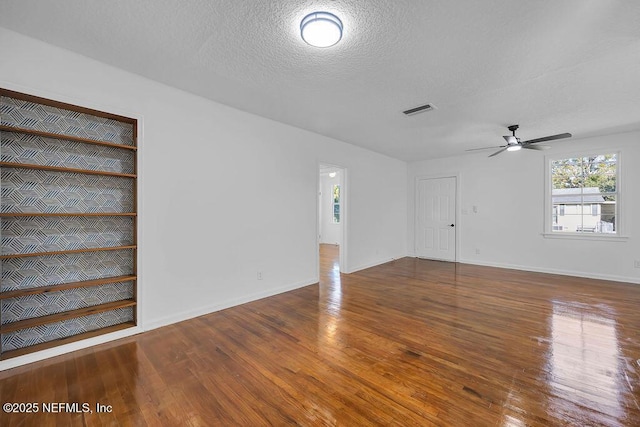 unfurnished living room with a textured ceiling, hardwood / wood-style flooring, and ceiling fan