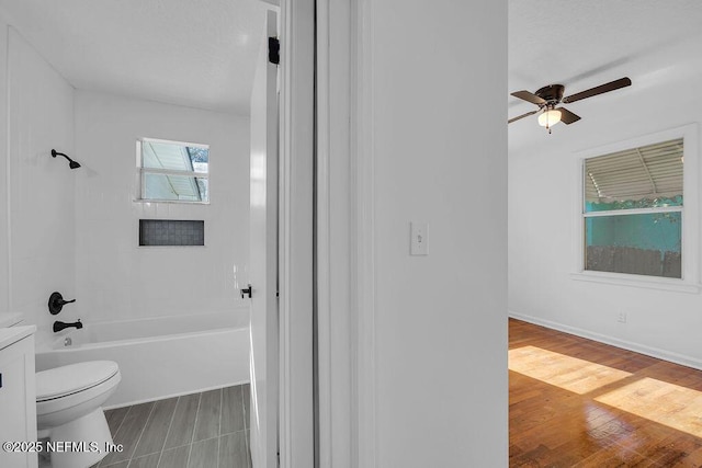 bathroom featuring shower / bathing tub combination, ceiling fan, toilet, and hardwood / wood-style floors