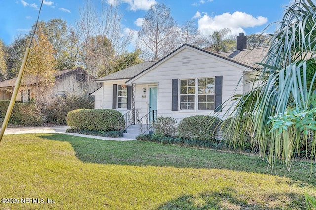 bungalow-style home with a front yard