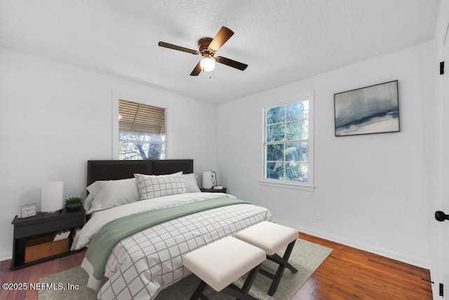 bedroom with hardwood / wood-style floors, a textured ceiling, and ceiling fan