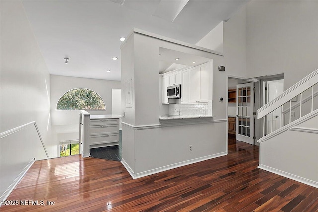 kitchen featuring white cabinets, decorative backsplash, and dark wood-type flooring