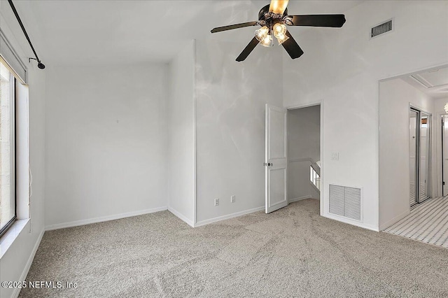 carpeted empty room featuring plenty of natural light and ceiling fan