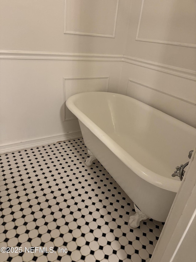 bathroom with tile patterned floors and a washtub