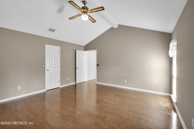 empty room featuring vaulted ceiling with beams, ceiling fan, and dark hardwood / wood-style floors