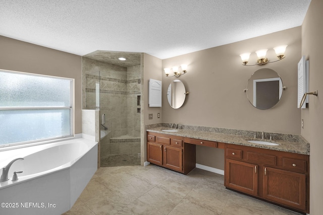 bathroom featuring plus walk in shower, vanity, and a textured ceiling