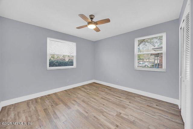 unfurnished bedroom featuring light hardwood / wood-style flooring, a closet, and ceiling fan