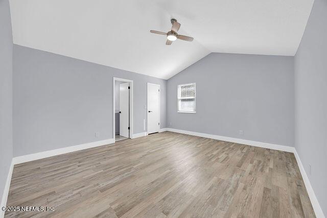 empty room featuring lofted ceiling, light hardwood / wood-style flooring, and ceiling fan