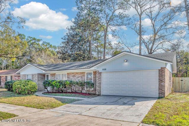 single story home with a garage and a front lawn