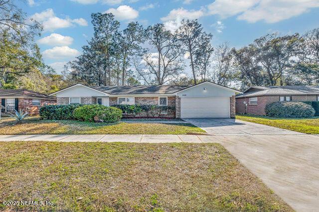 single story home with a garage and a front yard