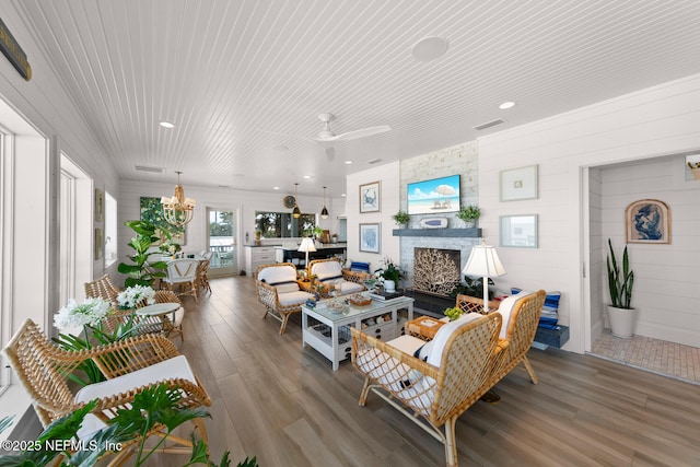 living room with ceiling fan, hardwood / wood-style floors, and a large fireplace