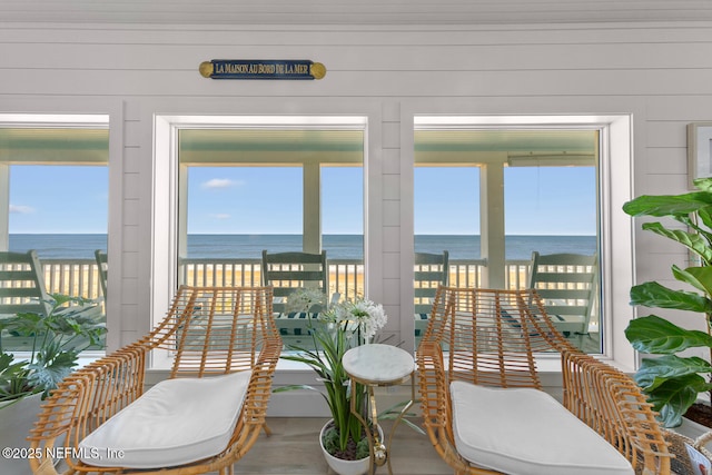 sunroom with a view of the beach and a water view