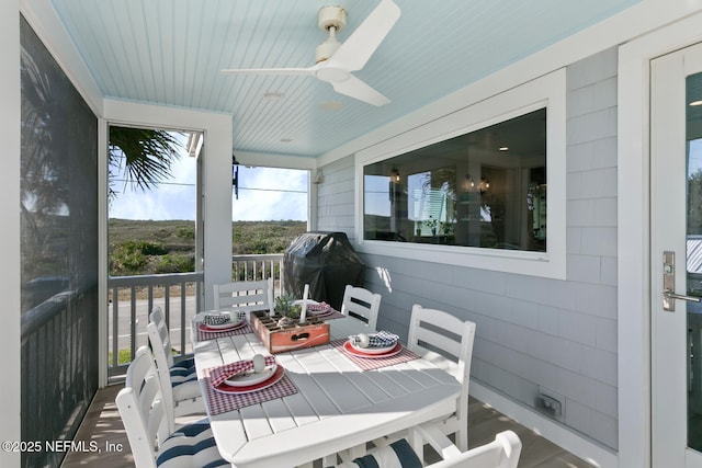 sunroom featuring ceiling fan and wood ceiling