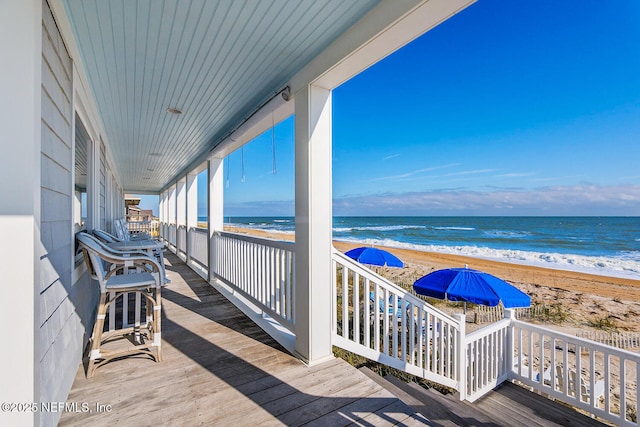 deck featuring a water view and a view of the beach