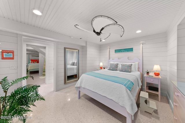 bedroom with ceiling fan and wooden walls