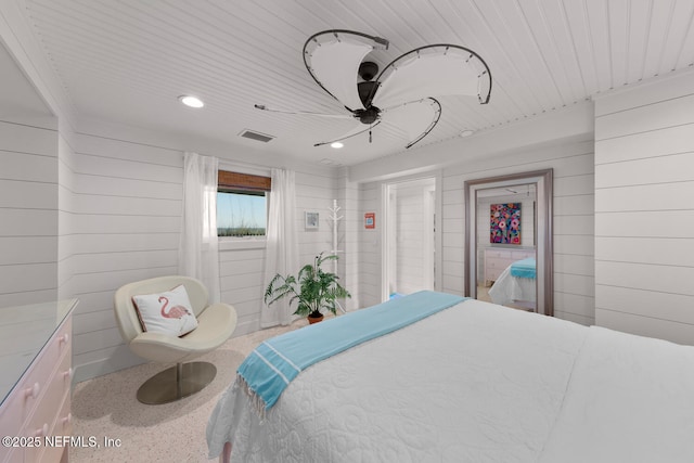 bedroom featuring ceiling fan and wood walls